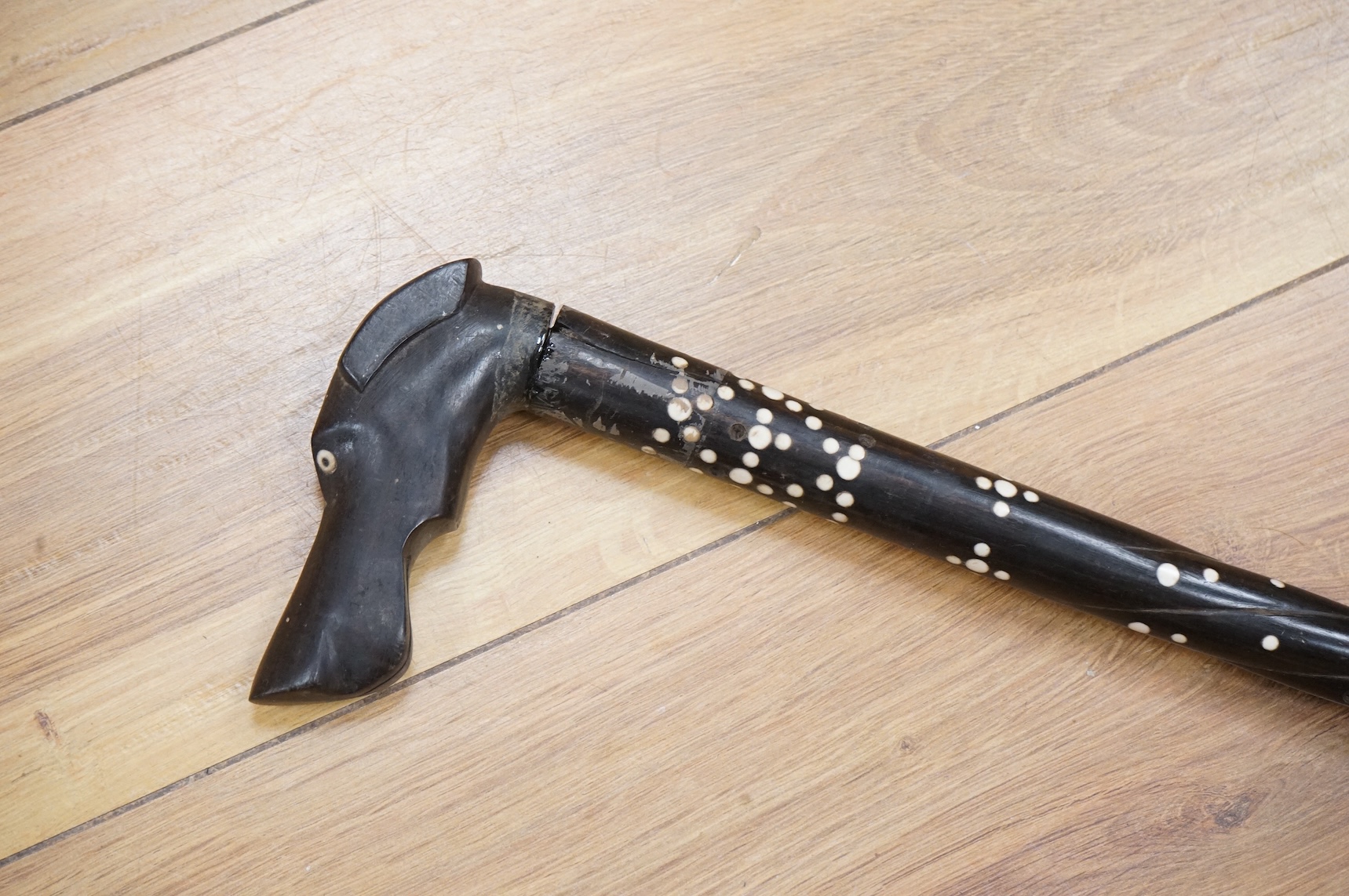 An ebony walking stick with bone inlay, the handle in the form of a dog's head, 88cm in length